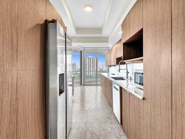 7000 Island Blvd Unit 1208, Aventura, FL 33160 - kitchen featuring modern cabinets, appliances with stainless steel finishes, light countertops, a wall of windows, and a city view