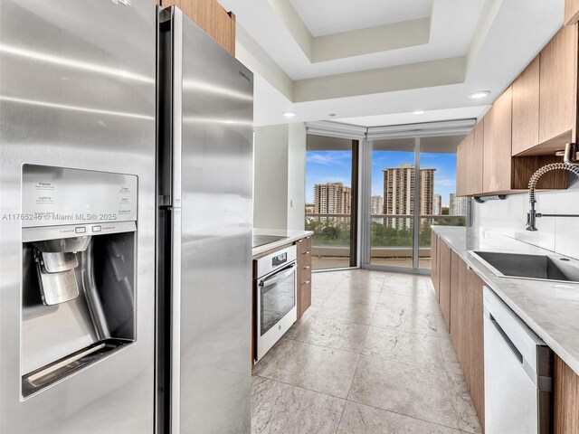 7000 Island Blvd Unit 1208, Aventura, FL 33160 - kitchen with stainless steel appliances, modern cabinets, a view of skyline, expansive windows, and brown cabinetry