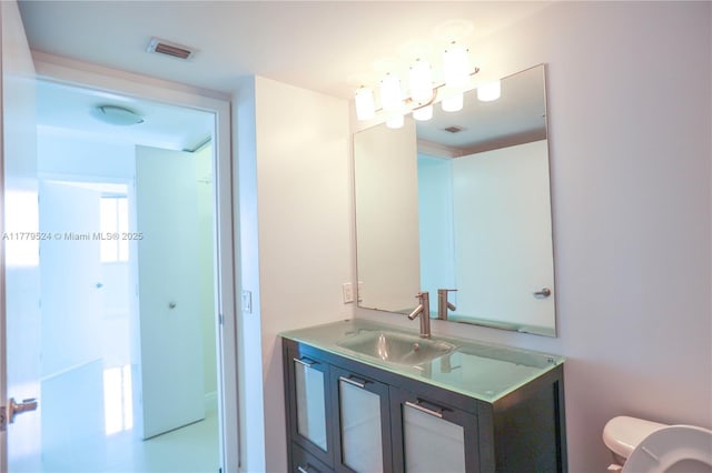 half bath featuring toilet, vanity, a notable chandelier, and visible vents