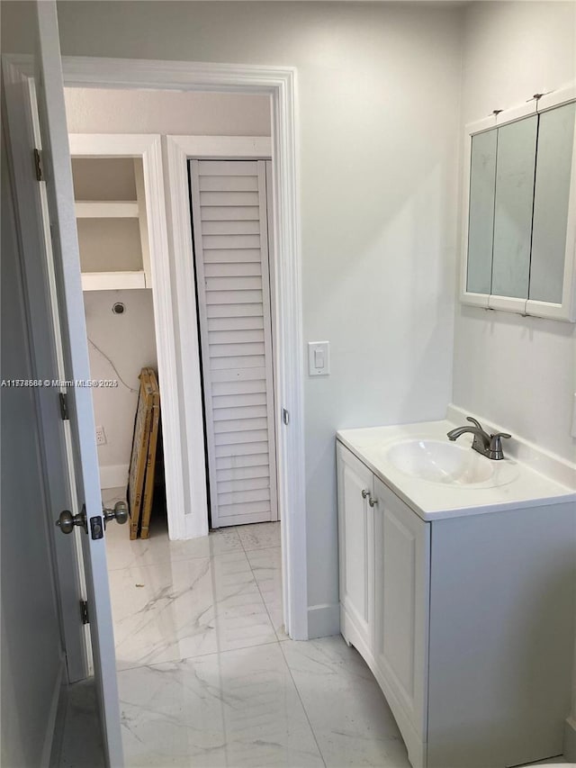 bathroom with vanity, marble finish floor, and baseboards