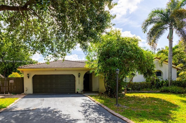 view of front of house with an attached garage, stucco siding, driveway, and a tile roof