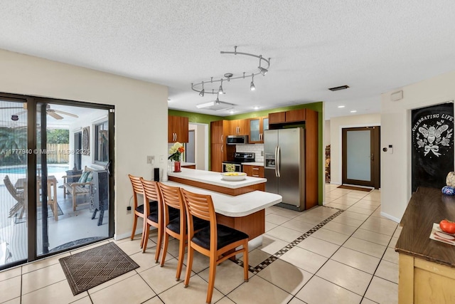 dining room with light tile patterned floors, baseboards, a ceiling fan, and a textured ceiling