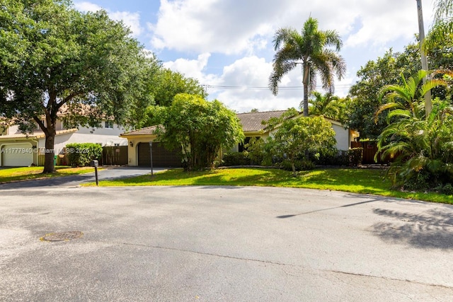 14811 Archerhall St, Davie, FL 33331 - obstructed view of property with a garage, driveway, stucco siding, and a tile roof