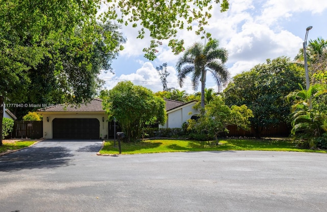 14811 Archerhall St, Davie, FL 33331 - view of front of home featuring asphalt driveway, a tile roof, stucco siding, and a garage