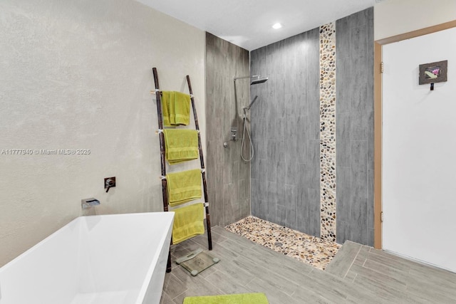 full bath with recessed lighting, a tile shower, and a soaking tub