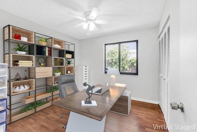 office area featuring baseboards, a ceiling fan, a textured ceiling, and wood finished floors