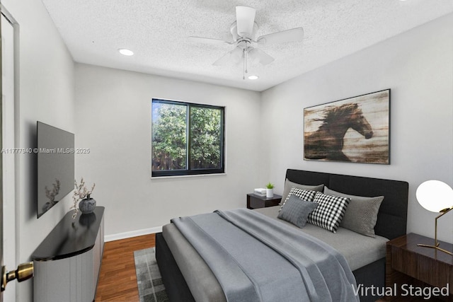 bedroom with dark wood-style flooring, a textured ceiling, recessed lighting, and ceiling fan