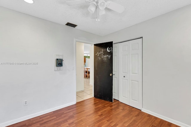 unfurnished bedroom featuring baseboards, visible vents, wood finished floors, and a closet