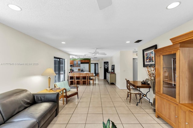 living area with a ceiling fan, visible vents, light tile patterned flooring, and recessed lighting