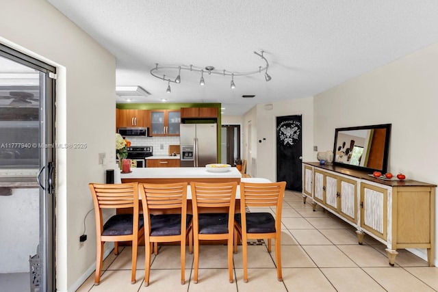 dining area with a textured ceiling and light tile patterned flooring
