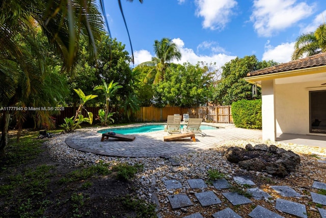 exterior space featuring a fenced in pool, a fenced backyard, and a patio area