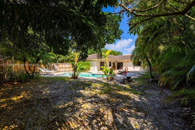 view of yard featuring fence, a fenced in pool, and a patio