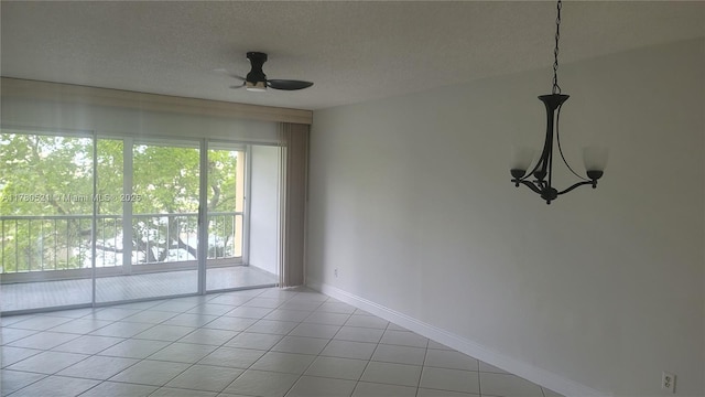 tiled empty room with baseboards, a ceiling fan, and a textured ceiling