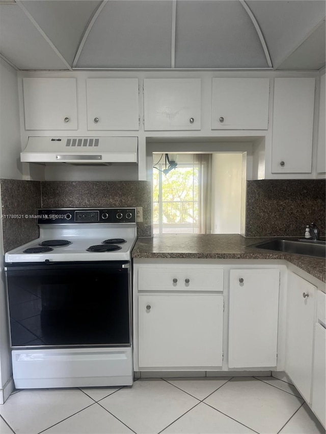 kitchen featuring electric range oven, a sink, under cabinet range hood, white cabinetry, and decorative backsplash