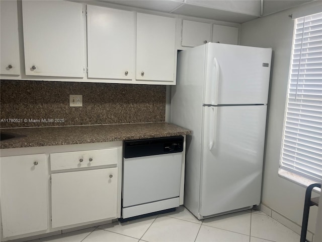 kitchen with light tile patterned floors, white cabinets, and white appliances