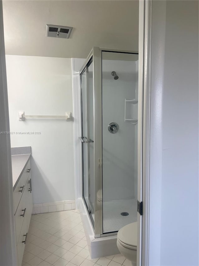 bathroom with a stall shower, vanity, visible vents, and tile patterned floors