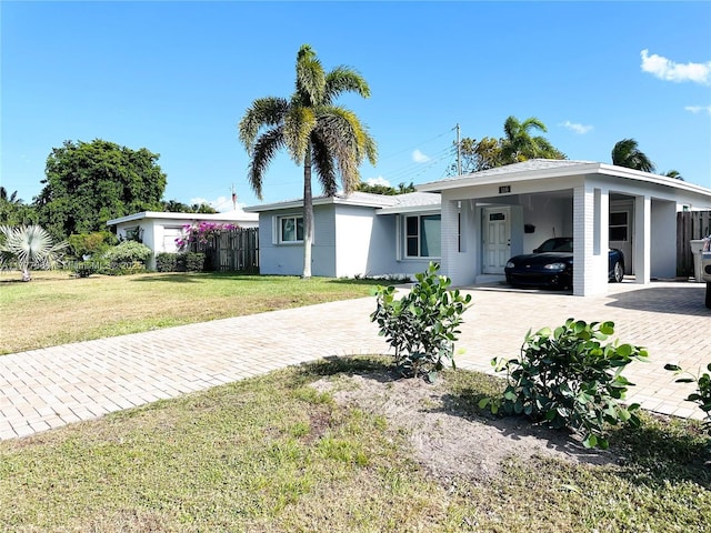 view of front of property with driveway, a front lawn, a carport, and fence