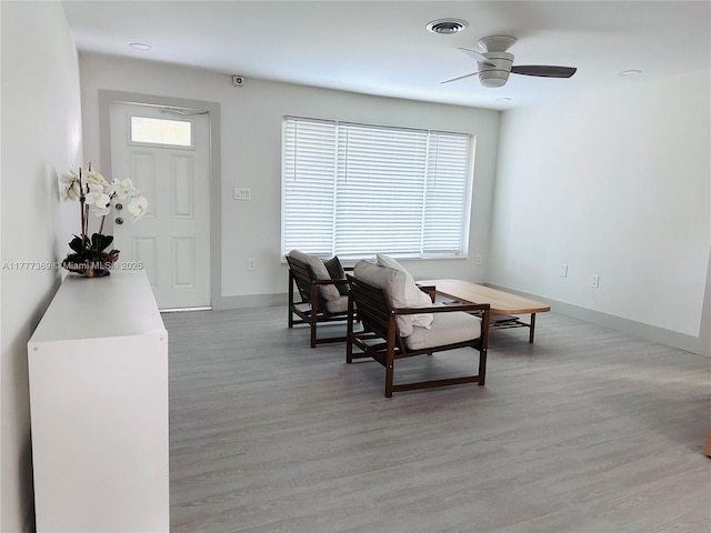 living area featuring ceiling fan, baseboards, visible vents, and light wood-style flooring