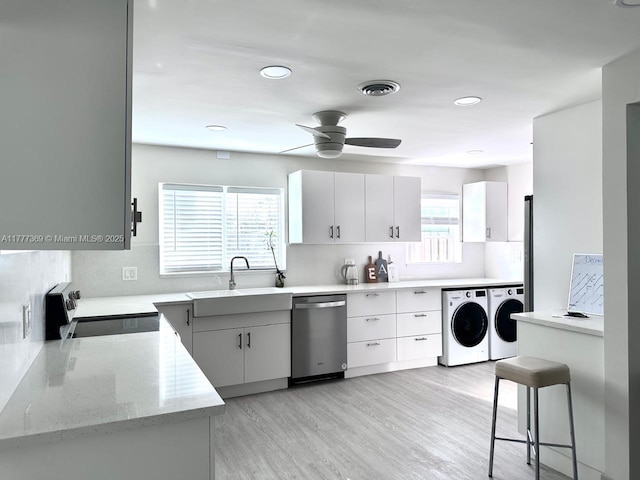 kitchen featuring range with electric cooktop, dishwasher, a ceiling fan, decorative backsplash, and separate washer and dryer