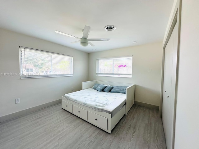 bedroom with ceiling fan, baseboards, wood finished floors, and visible vents