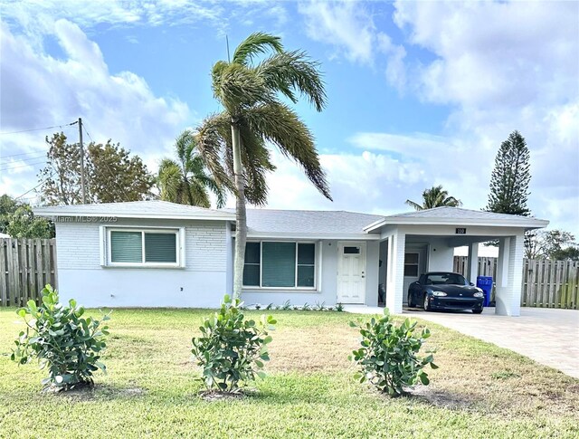 ranch-style home with fence, driveway, an attached carport, and a front yard