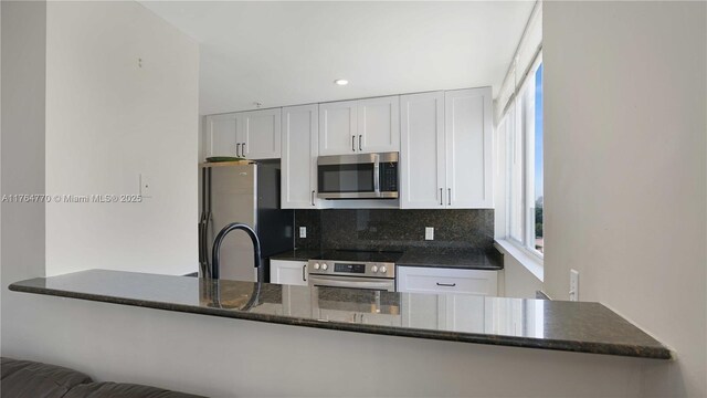 2400 SW 27th Ave Unit 706, Miami, FL 33145 - kitchen featuring appliances with stainless steel finishes, tasteful backsplash, white cabinets, plenty of natural light, and recessed lighting