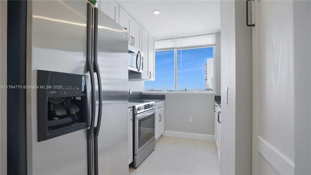 2400 SW 27th Ave Unit 706, Miami, FL 33145 - kitchen with stainless steel appliances, white cabinets, light tile patterned floors, baseboards, and recessed lighting
