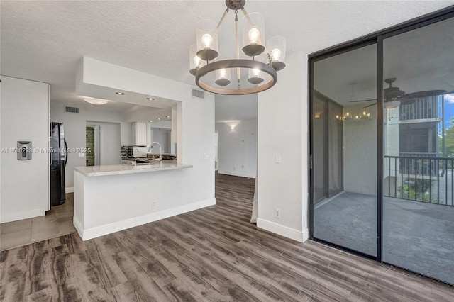 105 Lake Emerald Dr Unit 211, Oakland Park, FL 33309 - kitchen featuring ceiling fan with notable chandelier, freestanding refrigerator, visible vents, dark wood-style flooring, and a sink