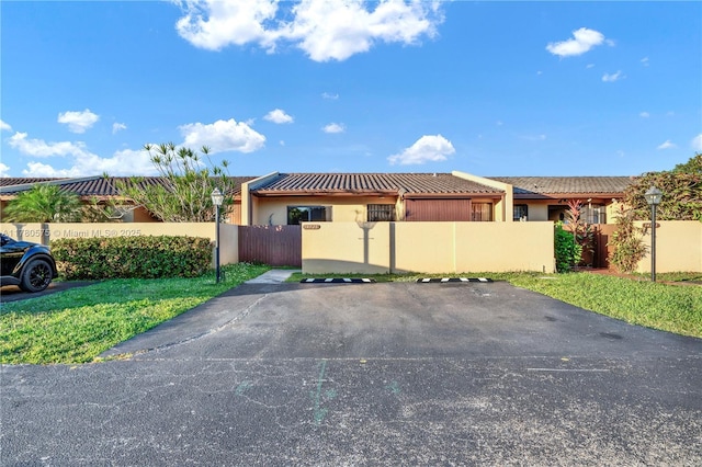 14723 SW 86th Ln, Miami, FL 33193 - view of home's exterior with a fenced front yard, uncovered parking, stucco siding, and a tiled roof
