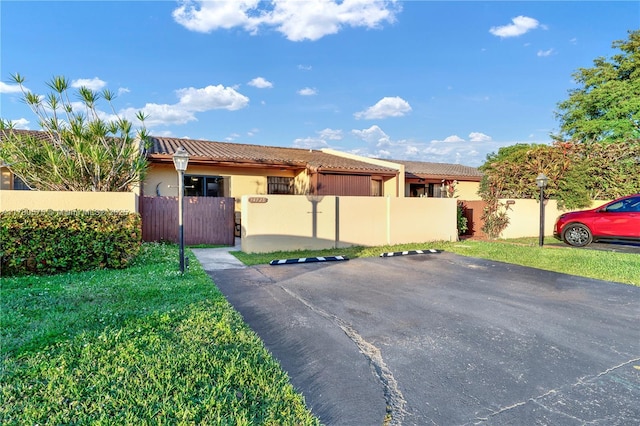 14723 SW 86th Ln, Miami, FL 33193 - view of front of home featuring a tile roof, a fenced front yard, stucco siding, and a gate