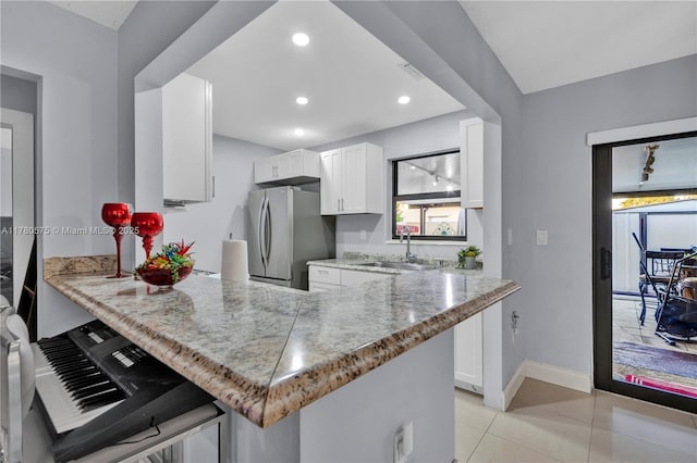 14723 SW 86th Ln, Miami, FL 33193 - kitchen with freestanding refrigerator, white cabinetry, a peninsula, light tile patterned floors, and recessed lighting