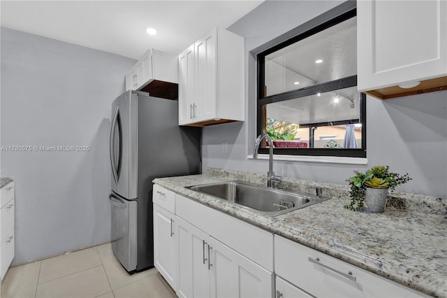 14723 SW 86th Ln, Miami, FL 33193 - kitchen featuring white cabinetry, light tile patterned floors, freestanding refrigerator, light stone countertops, and recessed lighting