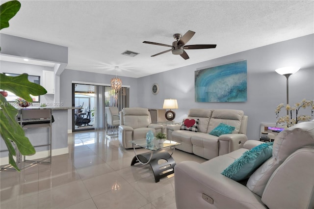 14723 SW 86th Ln, Miami, FL 33193 - living room featuring a ceiling fan, a textured ceiling, light tile patterned floors, and a chandelier