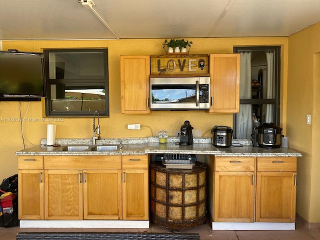 14723 SW 86th Ln, Miami, FL 33193 - kitchen featuring stainless steel microwave, light stone counters, and brown cabinets
