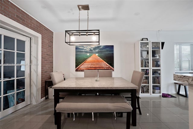tiled dining space featuring brick wall