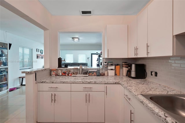 kitchen with white cabinetry, a healthy amount of sunlight, backsplash, and visible vents