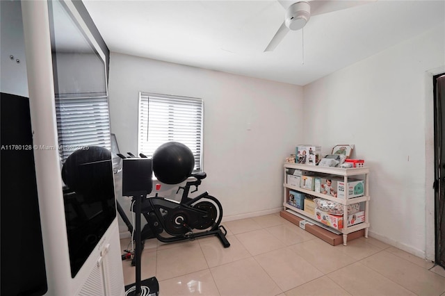workout area with tile patterned floors, ceiling fan, and baseboards
