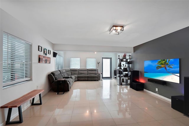 living area featuring light tile patterned floors and baseboards