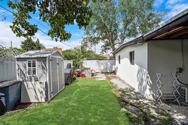 view of yard featuring a storage shed, an outbuilding, and a fenced backyard