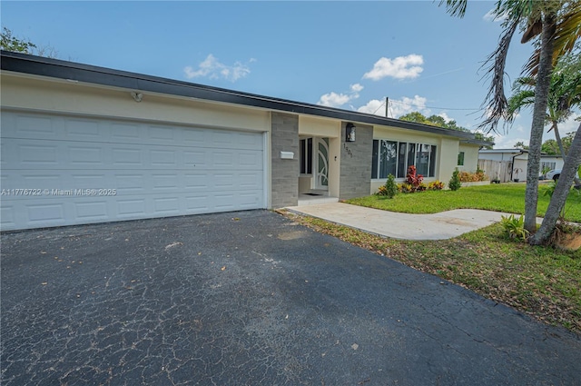 1901 NE 186th Dr, North Miami Beach, FL 33179 - ranch-style home with a front lawn, a garage, and aphalt driveway