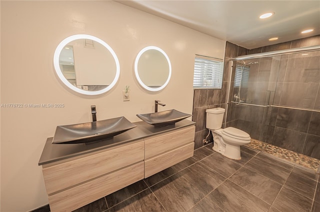 1901 NE 186th Dr, North Miami Beach, FL 33179 - bathroom featuring toilet, double vanity, a sink, and tiled shower
