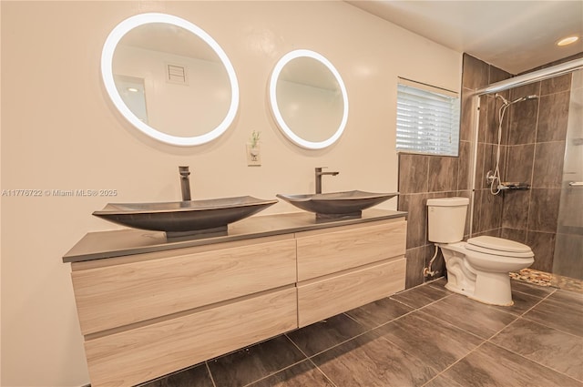 1901 NE 186th Dr, North Miami Beach, FL 33179 - bathroom featuring toilet, a tile shower, double vanity, and a sink
