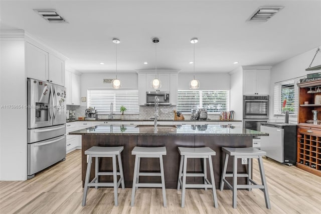 19050 SW 144th Ave, Miami, FL 33177 - kitchen with stainless steel appliances, backsplash, white cabinets, a kitchen bar, and recessed lighting