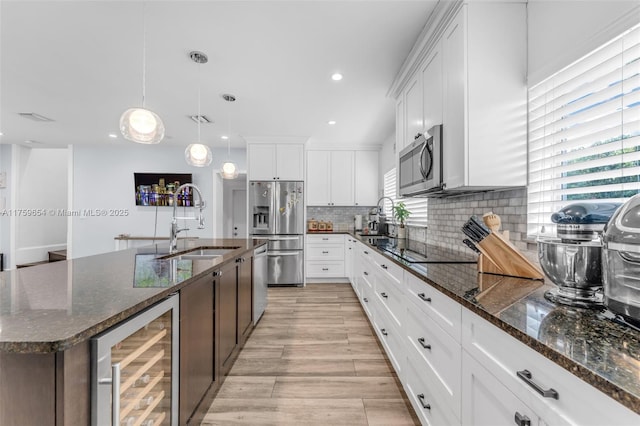 19050 SW 144th Ave, Miami, FL 33177 - kitchen featuring appliances with stainless steel finishes, a sink, wine cooler, healthy amount of natural light, and recessed lighting