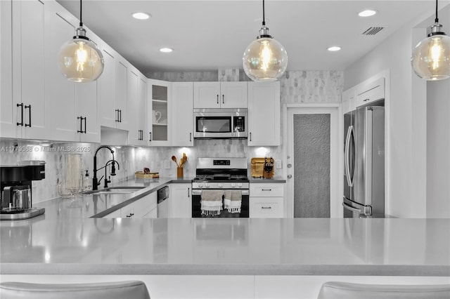 2243 Bayview Ln, North Miami, FL 33181 - kitchen with visible vents, glass insert cabinets, white cabinets, a sink, and appliances with stainless steel finishes