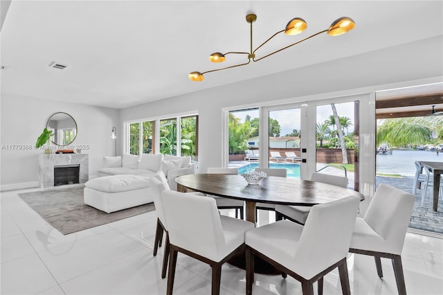 2243 Bayview Ln, North Miami, FL 33181 - dining room with a chandelier, baseboards, visible vents, and a fireplace