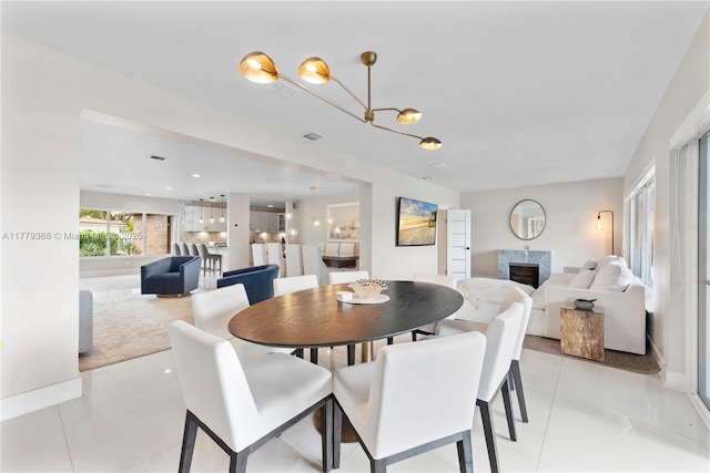 2243 Bayview Ln, North Miami, FL 33181 - dining area featuring light tile patterned floors, visible vents, a fireplace, and a chandelier