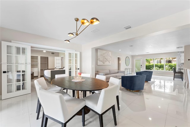 2243 Bayview Ln, North Miami, FL 33181 - dining space featuring light tile patterned floors, an inviting chandelier, french doors, and visible vents