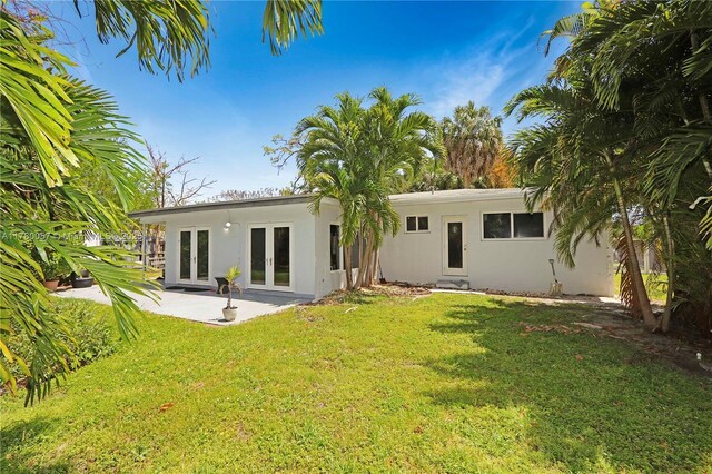 back of house with a yard, french doors, a patio, and stucco siding