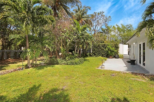 view of yard with a patio area, french doors, and a fenced backyard